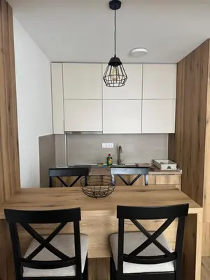 a kitchen with a wooden table with two chairs at Apartman Pogled Contra in Kopaonik