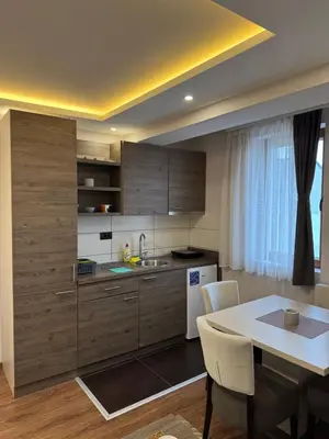 a kitchen with a table and a table and a dining room at Apartmani Glamur Kopaonik in Kopaonik
