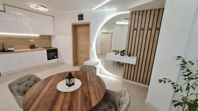 a kitchen and dining room with a wooden table and chairs at Luxury Apartment Paraćin - City Center in Paraćin