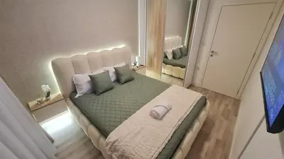 a bedroom with a large bed with green sheets and pillows at Luxury Apartment Paraćin - City Center in Paraćin
