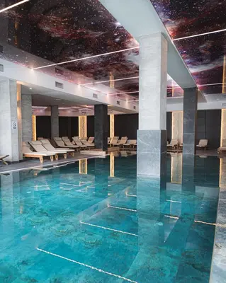 a swimming pool with blue water in a building at Hill View B121, Kopaonik in Kopaonik
