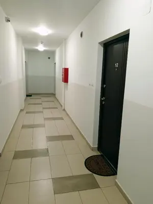 a hallway with a black door and a tile floor at Apartman Vuk in Ćuprija