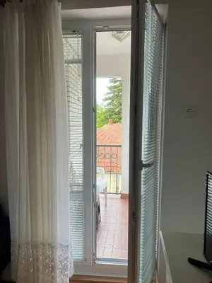 a sliding glass door with a view of a balcony at Apartmani Vrnjacka Banja 7 in Vrnjačka Banja