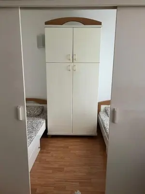 a closet with a white cabinet in a room at Apartmani Vrnjacka Banja 7 in Vrnjačka Banja