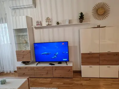 a living room with a flat screen tv on a cabinet at Slatinski mir in Vrnjačka Banja