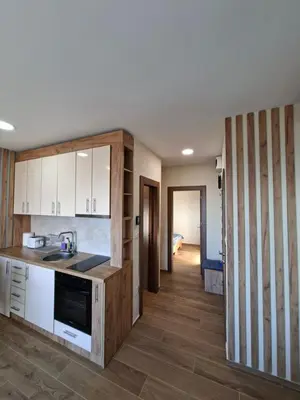 a kitchen with white cabinets and a counter top at Nebeska Treska in Kopaonik