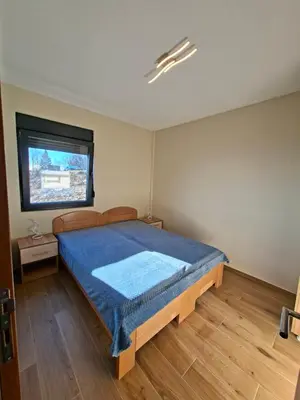 a bedroom with a large bed with a blue blanket at Nebeska Treska in Kopaonik