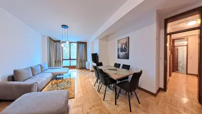a living room with a couch and a table and chairs at Apartmani Central 2 & Free Parking in Vrnjačka Banja