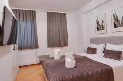 a room with two beds and a stuffed animal on the bed at Apartmani Central 2 & Free Parking in Vrnjačka Banja
