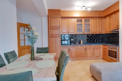 a kitchen with a table with a vase of flowers on it at Apartmani Central 2 & Free Parking in Vrnjačka Banja