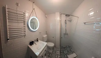 a white bathroom with a sink and a mirror at Apartmani Central 2 & Free Parking in Vrnjačka Banja