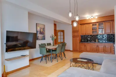 a living room with a couch and a table with chairs at Apartmani Central 2 & Free Parking in Vrnjačka Banja