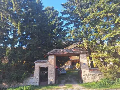 a gate to a house with a car parked in a driveway at Domaćinstvo Drenak - Bešnjaja in Kragujevac