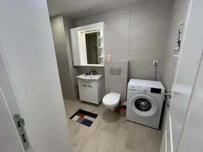 a bathroom with a washing machine and a toilet at Apartman Petruska Park in Paraćin