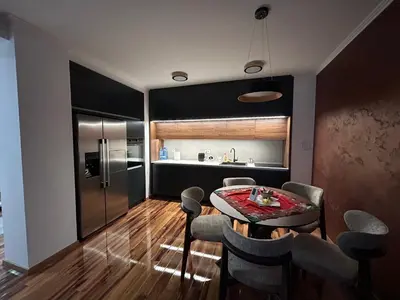 a kitchen and dining room with a table and a refrigerator at Apartman Petruska Park in Paraćin