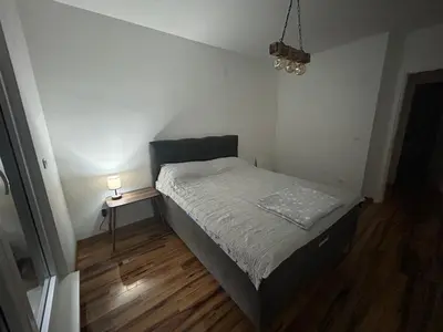 a small bedroom with a bed and a night stand at Apartman Petruska Park in Paraćin
