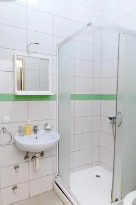 a white bathroom with a sink and a shower at Studio Merlin 2 in Soko Banja
