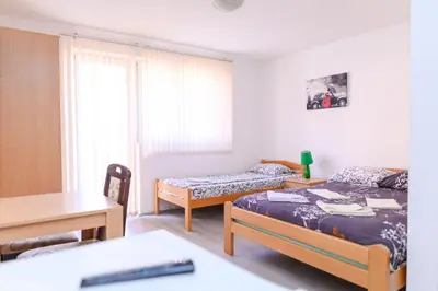 a bedroom with two beds and a desk and a table at Studio Merlin 4 in Soko Banja