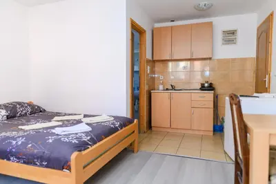 a small bedroom with a bed and a kitchen at Studio Merlin 4 in Soko Banja