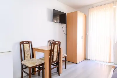 a room with a table and chairs and a television at Studio Merlin 4 in Soko Banja