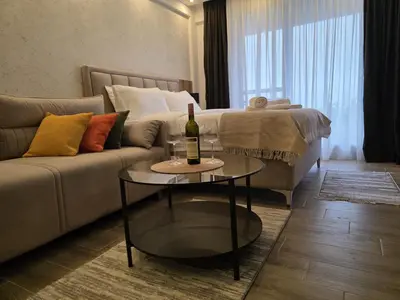 a living room with a couch and a bottle of wine on a table at Lyra Prestige Residence Hill in Kopaonik
