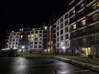 a parking lot in front of a building at night at Lyra Prestige Residence Hill in Kopaonik