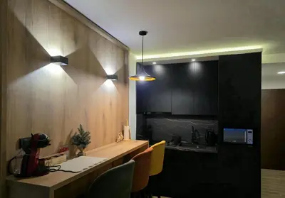 a kitchen with a counter with chairs and a sink at Lyra Prestige Residence Hill in Kopaonik