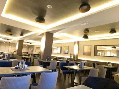a dining room with tables and chairs and lights at Lyra Prestige Residence Hill in Kopaonik