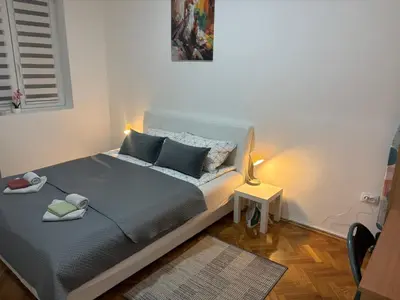 a bedroom with a bed with blue pillows at 3M Lux Niš in Niš