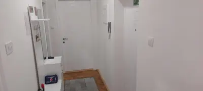 a hallway with white walls and a mirror at 3M Lux Niš in Niš
