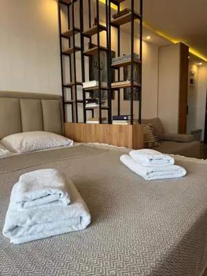 two towels are stacked on a bed in a room at Residence Hill A42 in Kopaonik