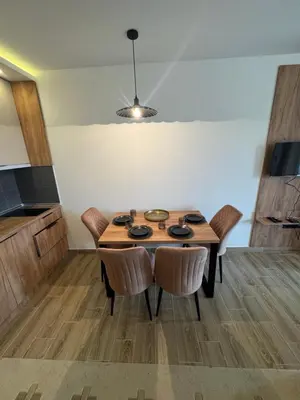 a kitchen with a wooden table and some chairs at Residence Hill A42 in Kopaonik