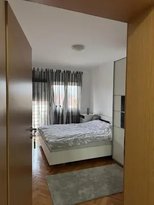 a bedroom with a bed and a window at bozicapartments in Jagodina