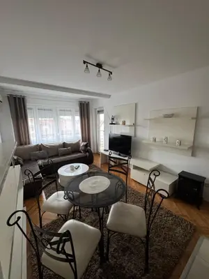 a living room with a couch and tables and chairs at bozicapartments in Jagodina