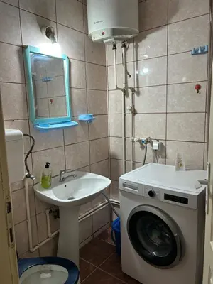 a bathroom with a washing machine and a sink at Stan in Niš