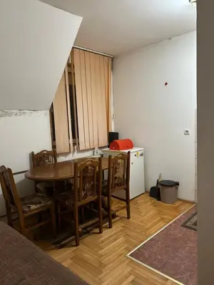 a kitchen with a table and chairs in a room at Stan in Niš