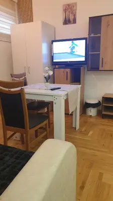 a living room with a white desk and a tv at Apartman Boki X in Vrnjačka Banja