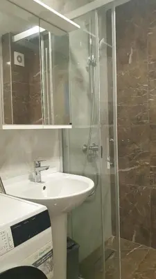 a bathroom with a sink and a glass shower at Apartman Boki X in Vrnjačka Banja