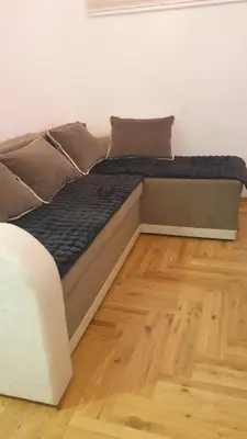 a bed sitting on top of a wooden floor at Apartman Boki X in Vrnjačka Banja