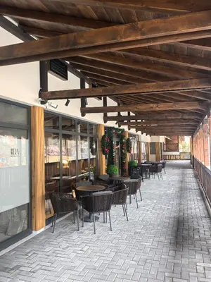 a patio with tables and chairs in a restaurant at Apartman Stagira - Bela Reka Gondola, Kopaonik in Brzeće