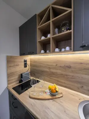 a kitchen counter with a plate of fruit and wine glasses at Apartman Stagira - Bela Reka Gondola, Kopaonik in Brzeće