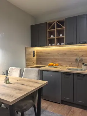 a kitchen with a wooden table and a table and chairs at Apartman Stagira - Bela Reka Gondola, Kopaonik in Brzeće