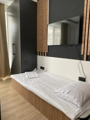 a bedroom with a bed with white sheets and a mirror at Mountain Soul - Residence Hill in Kopaonik