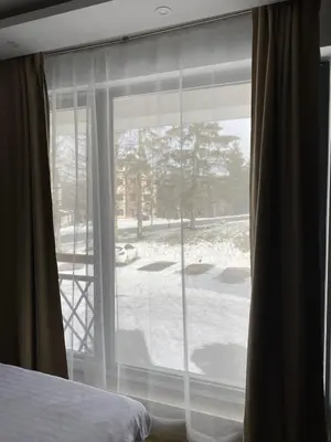a bedroom window with a view of a snow covered yard at Mountain Soul - Residence Hill in Kopaonik