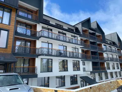 an apartment building with balconies and a car parked in front at Mountain Soul - Residence Hill in Kopaonik