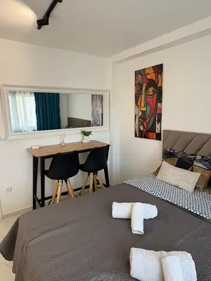 a bedroom with a bed and a desk and a table at Nik 2 in Kruševac
