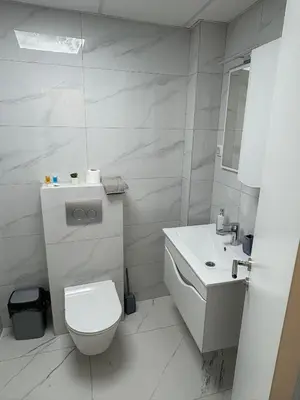a white bathroom with a toilet and a sink at Nik 2 in Kruševac