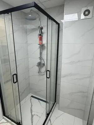 a shower with a glass door in a bathroom at Nik 2 in Kruševac