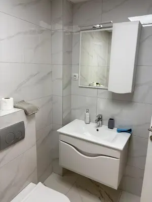 a white bathroom with a sink and a mirror at Nik 2 in Kruševac