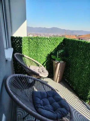 a chair with a blue cushion sitting on a balcony at Lux Veritas- besplatan parking-100 metara od Vinarije Grabak in Vrnjačka Banja